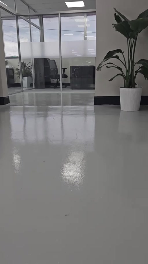 Gray floor coating in a dealership office with glass partitions