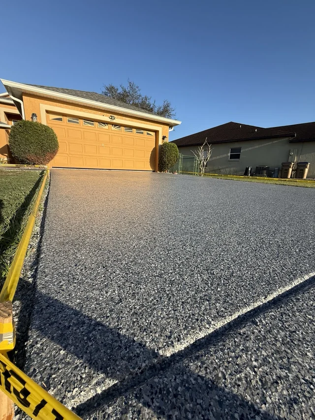 Complete decorative full-flake driveway in front of a yellow two-car garage