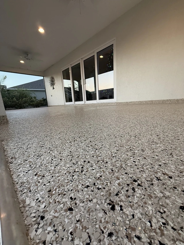 Covered patio with glass doors and a beige decorative flake floor by EpoX Floor Coatings
