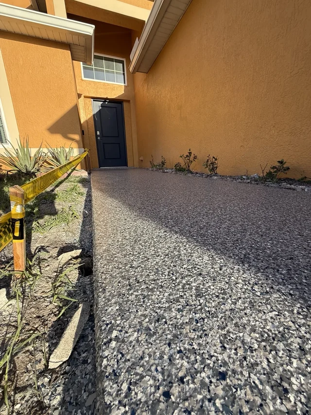 Decorative full-flake walkway leading to the blue front door of a home